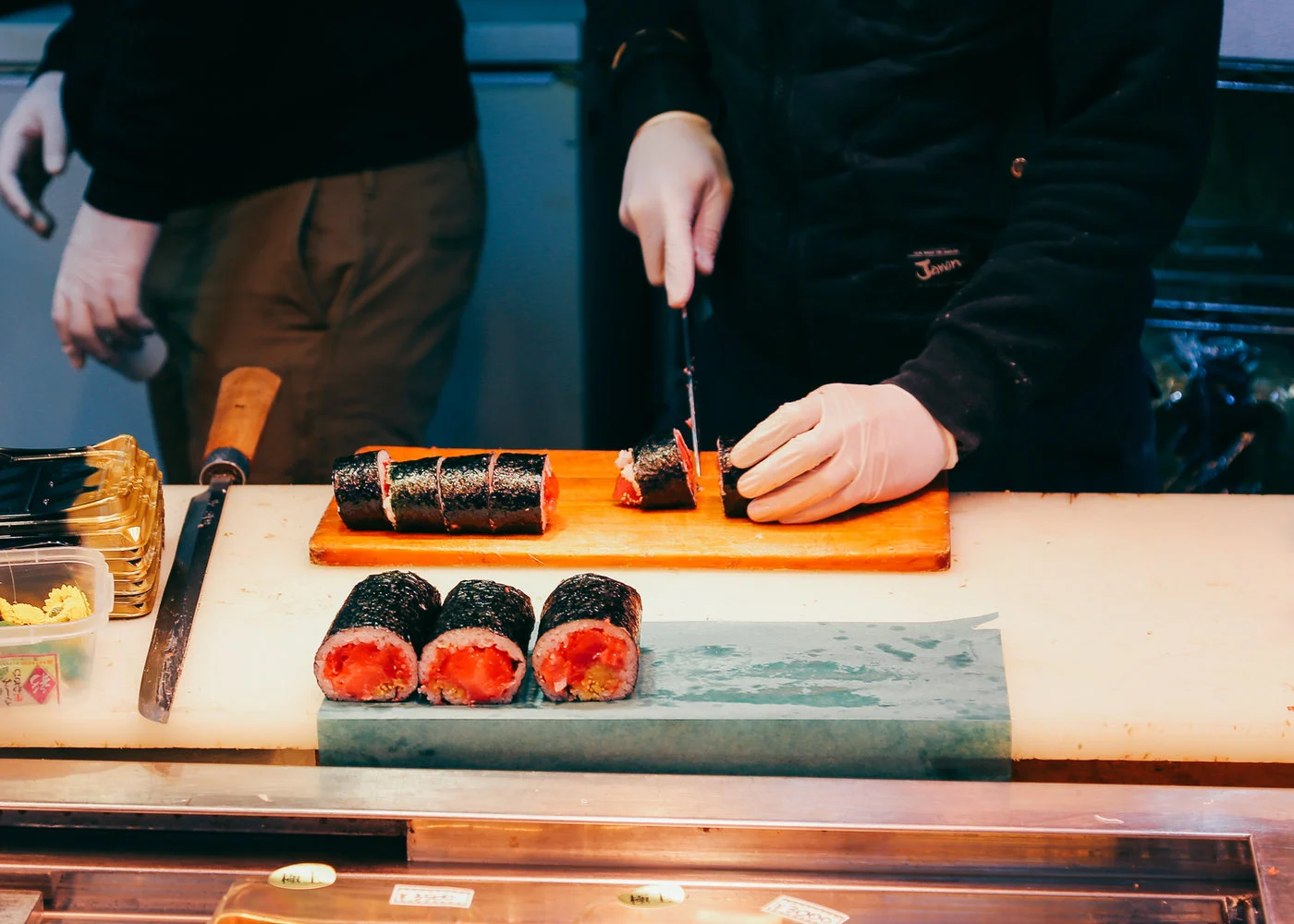 Chef slicing a freshly made sushi roll at the Sushi Go-En counter in Salisbury, Brisbane